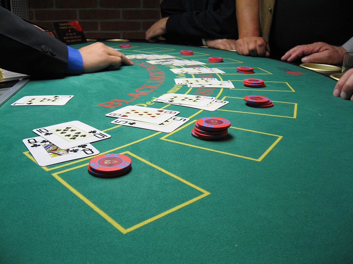 Spillere og sjetonger rundt et blackjackbord